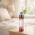 Bottle of 'Rose Elegance' spray on a nightstand with a bedroom background